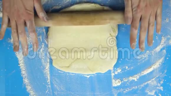 慢镜头面包师用擀面杖揉和翻转面团顶部视图视频的预览图