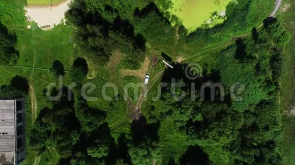 汽车沿着绿树和灌木丛之间的乡村道路行驶视频的预览图