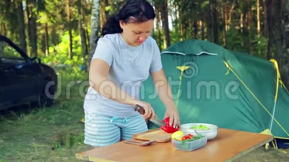 3年轻女子野餐时用刀切桃花刀做水果沙拉视频的预览图
