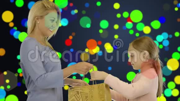 妈妈和女儿用礼品袋互相送礼物纸屑圈的背景视频的预览图