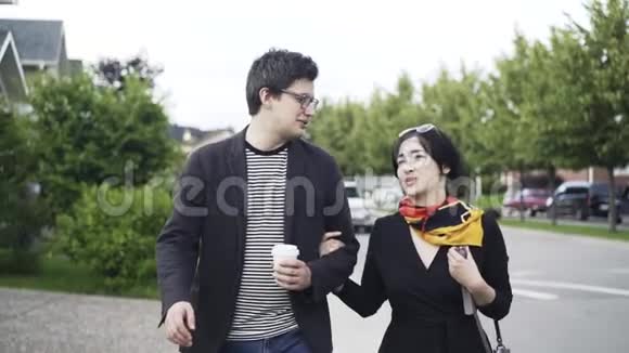 年轻夫妇在郊区的街道上散步和交谈视频的预览图