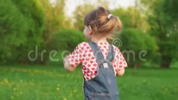 晴朗的夏日可爱的小女孩在公园里奔跑视频的预览图
