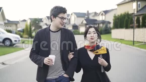 年轻夫妇走在郊区的街道上视频的预览图