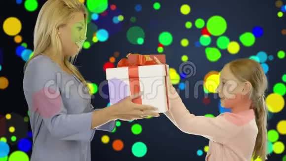 一个女孩和一个年轻的女人用盒子互相送礼物喜庆多彩的背景像纸屑视频的预览图