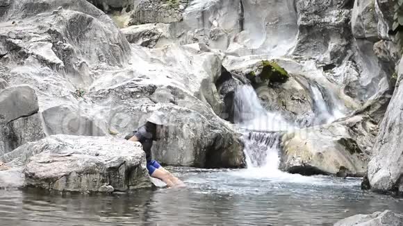 女人在岩石上休息享受水视频的预览图