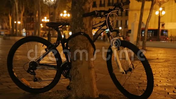 夜间城市公园自行车系在树上环保交通视频的预览图