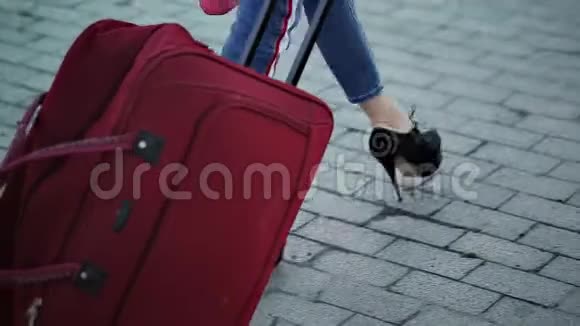 一个女人带着一个轮子的手提箱在铁路站台上发生双脚在站台上行走乘客与视频的预览图