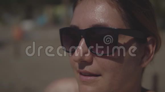 夏天在海滩上晒太阳的年轻女子视频的预览图