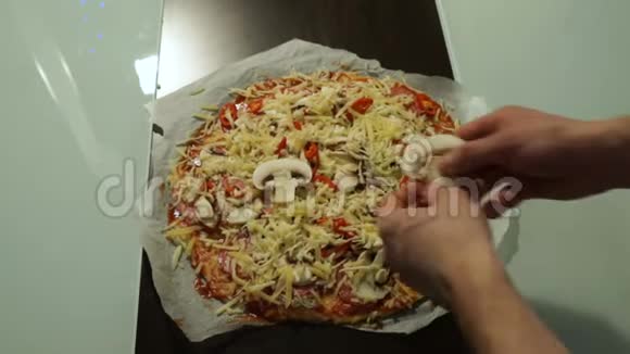 厨师把蘑菇放在生披萨特写上烹饪披萨视频的预览图