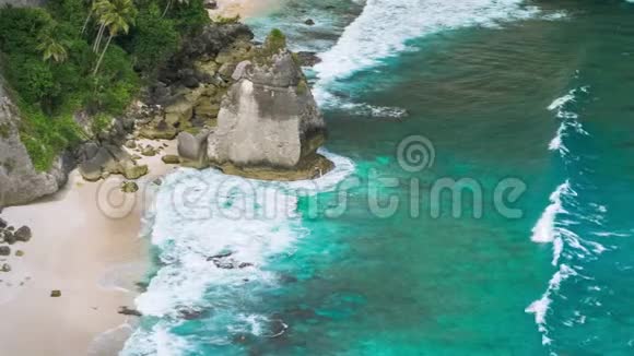 在印度尼西亚努沙佩尼达岛的Atuh海滩美丽的手掌在海洋中的岩石视频的预览图