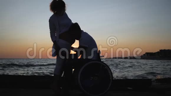 残疾人在轮椅上晚上听妻子的腹部残废的爱情怀孕的女性与无效的丈夫视频的预览图