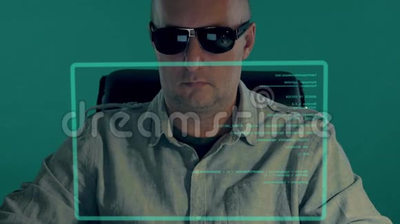 秃顶的白人军官坐在虚拟屏幕和输入程序代码前面戴黑眼镜的人写剧本视频的预览图