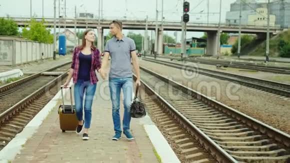 一对相爱的夫妇牵着手沿着奥克拉沿着铁路一起走视频的预览图