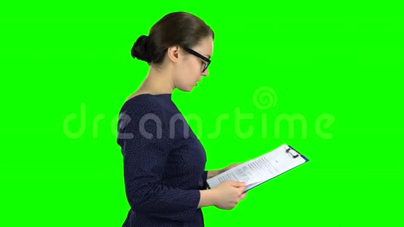 女人在街上拿着一张纸平板电脑绿色屏幕侧视图视频的预览图