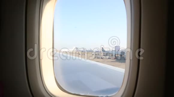 亚洲女孩从飞机上透过窗户看机场视频的预览图