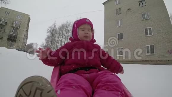幼儿在雪地上缓慢地滑过雪橇视频的预览图