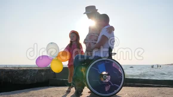 有幸运儿的轮椅上的爱人残疾人考虑怀孕妈妈度假视频的预览图
