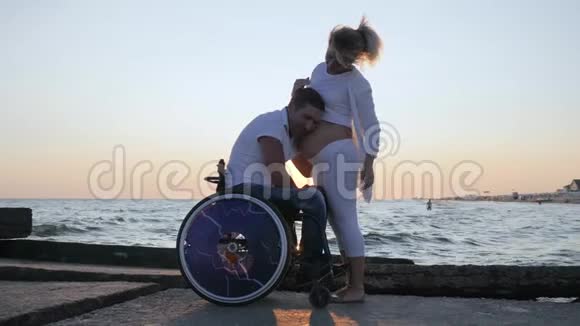 残疾人大肚子在堤上抚女残疾人坐轮椅听腹视频的预览图
