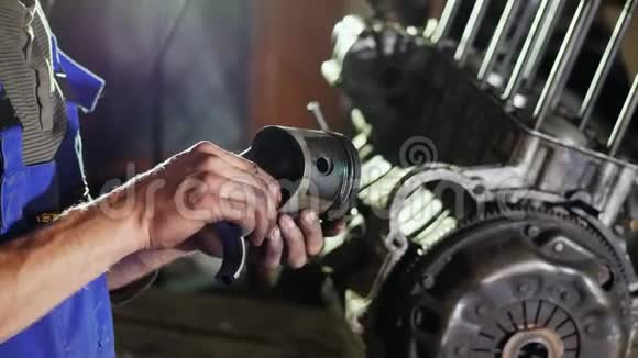 机械师把汽车的废活塞握在手里视频的预览图