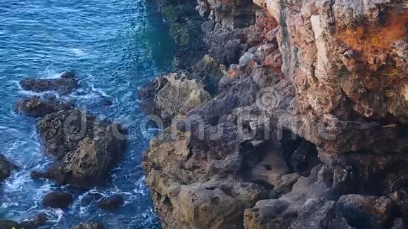 在岩石悬崖底部荡漾的水狂野的自然前往海岸视频的预览图