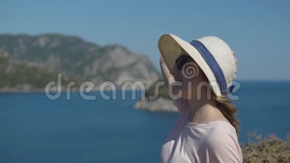 阳光明媚的夏日快乐的年轻女孩戴着帽子的游客欣赏自由和美丽的自然视频的预览图