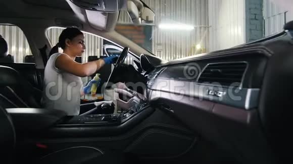 一名年轻女子清洁汽车方向盘视频的预览图
