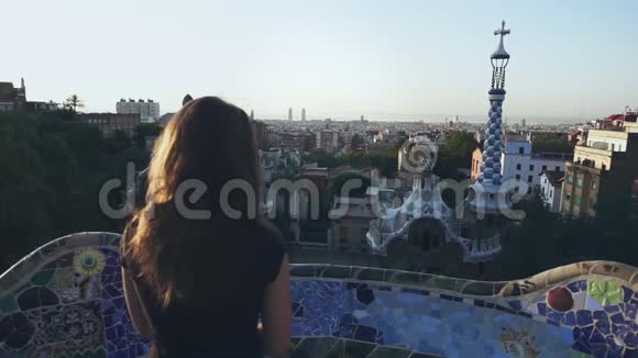 女人在观景台上看巴塞罗那的城市景观世界旅行视频的预览图