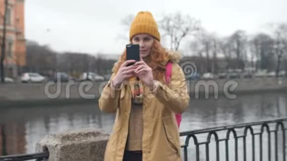 年轻的红发白种人女人在城市里自拍视频的预览图
