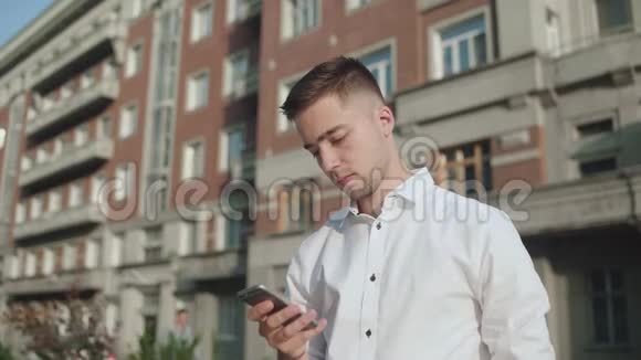 男人用智能手机在经典建筑的背景下视频的预览图