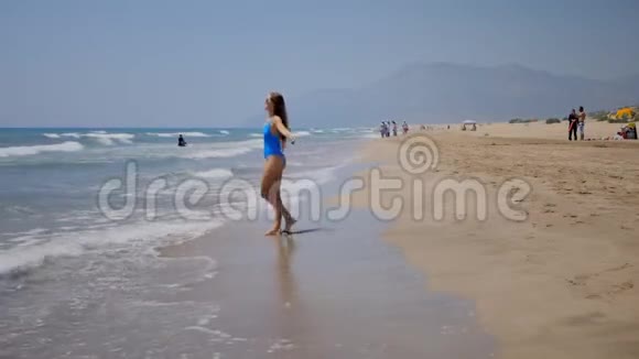 年轻女子在沙滩上玩视频的预览图