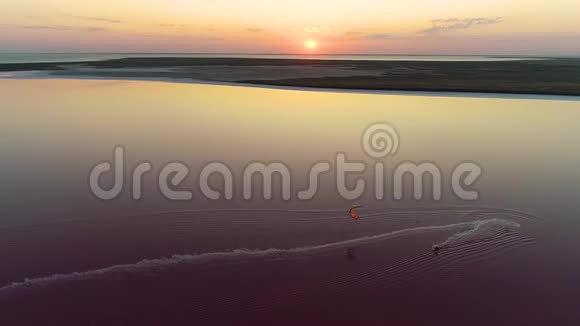 空中射击风筝与一个明亮的训练风筝在粉红色的湖中央视频的预览图