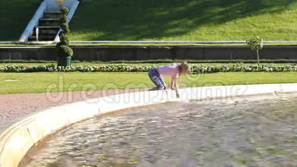 女孩走在喷泉旁玩水溅水和欢乐视频的预览图