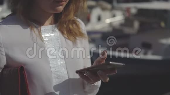 一群商务女性手里拿着智能手机站在模糊的船的背景上视频的预览图