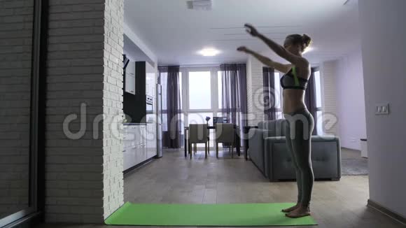 年轻的健康女性在家中靠墙做倒立视频的预览图