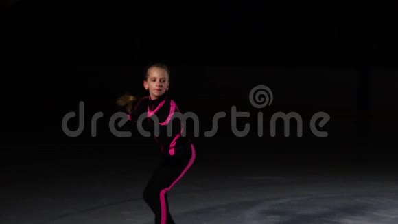 一个小女孩在冰场上参加了一场未来主义的滑冰表演旋转跳跃摄像机在移动视频的预览图