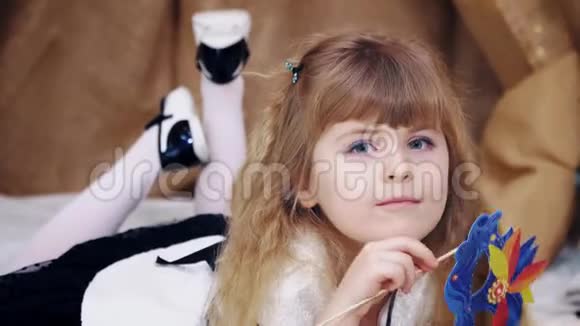 快乐可爱的金发小女孩躺着戴着面具摆姿势视频的预览图