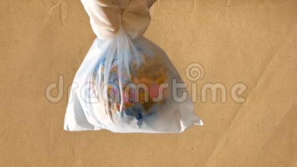 一个十几岁的女孩手里拿着一个塑料袋里面有一个迷你地球仪再生纸背景合适的镜头视频的预览图