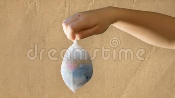 一个十几岁的女孩手里拿着一个塑料袋里面有一个迷你地球仪再生纸背景合适的镜头视频的预览图