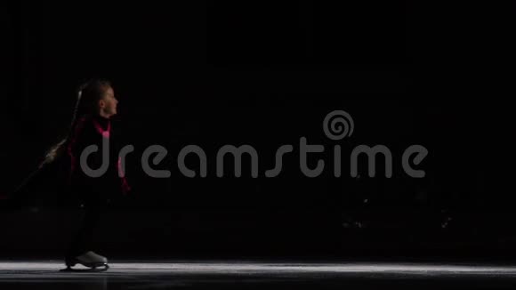 一个小女孩在冰场上参加了一场未来主义的滑冰表演旋转跳跃摄像机在移动视频的预览图