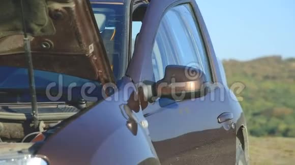 一个金发女孩在她的SUV上发现了一个错误下车打开引擎盖外景视频的预览图