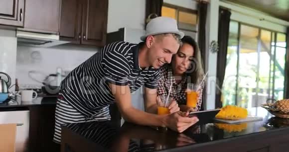 夫妻用平板电脑自拍照年轻男女在厨房工作室现代家庭内部视频的预览图