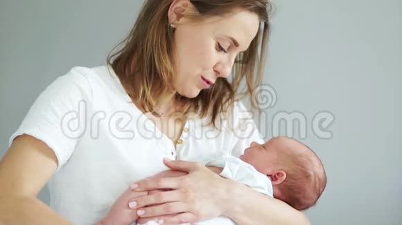 幸福妈妈抱着新生婴儿抱在怀里的特写镜头母亲和孩子快乐熟睡的孩子视频的预览图
