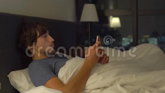 男人和女人躺在床上男人拿着智能手机而女人在睡觉婚姻和两性问题视频的预览图