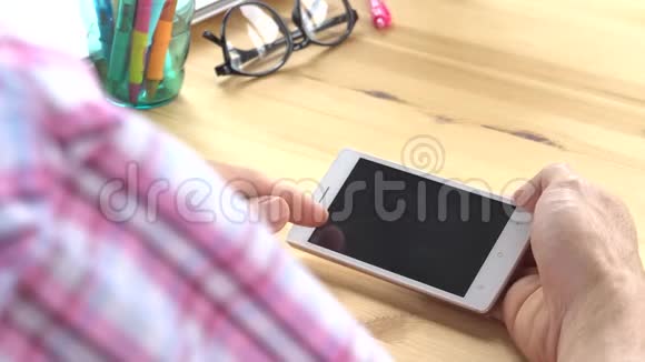 粉红斯科特衬衫商人滑动变焦触摸智能手机在家庭办公室视频的预览图
