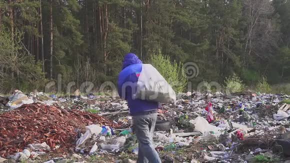 一个流浪汉在垃圾堆里背着个包的画像袋子里是空瓶子视频的预览图