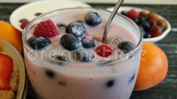 小屋奶酪酸奶草莓慢动作自制蓝莓健康传统饮食白色木制背景视频的预览图