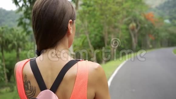 美丽的热带雨林带着一位年轻的女旅行者在进入泰国森林的路上女人在雨林里散步视频的预览图