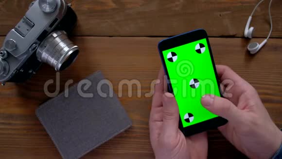 男性使用智能手机木桌上有绿色屏幕视频的预览图