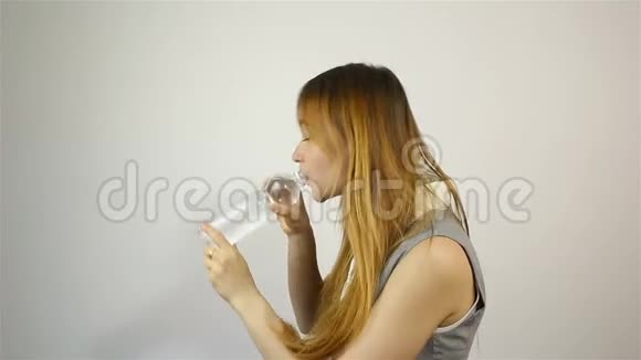 美丽的年轻女子打开瓶子喝水视频的预览图