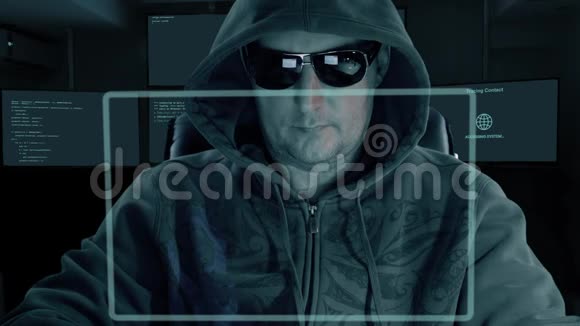 戴着头巾和墨镜的黑客坐在虚拟屏幕前为密码解密编写代码黑客们视频的预览图